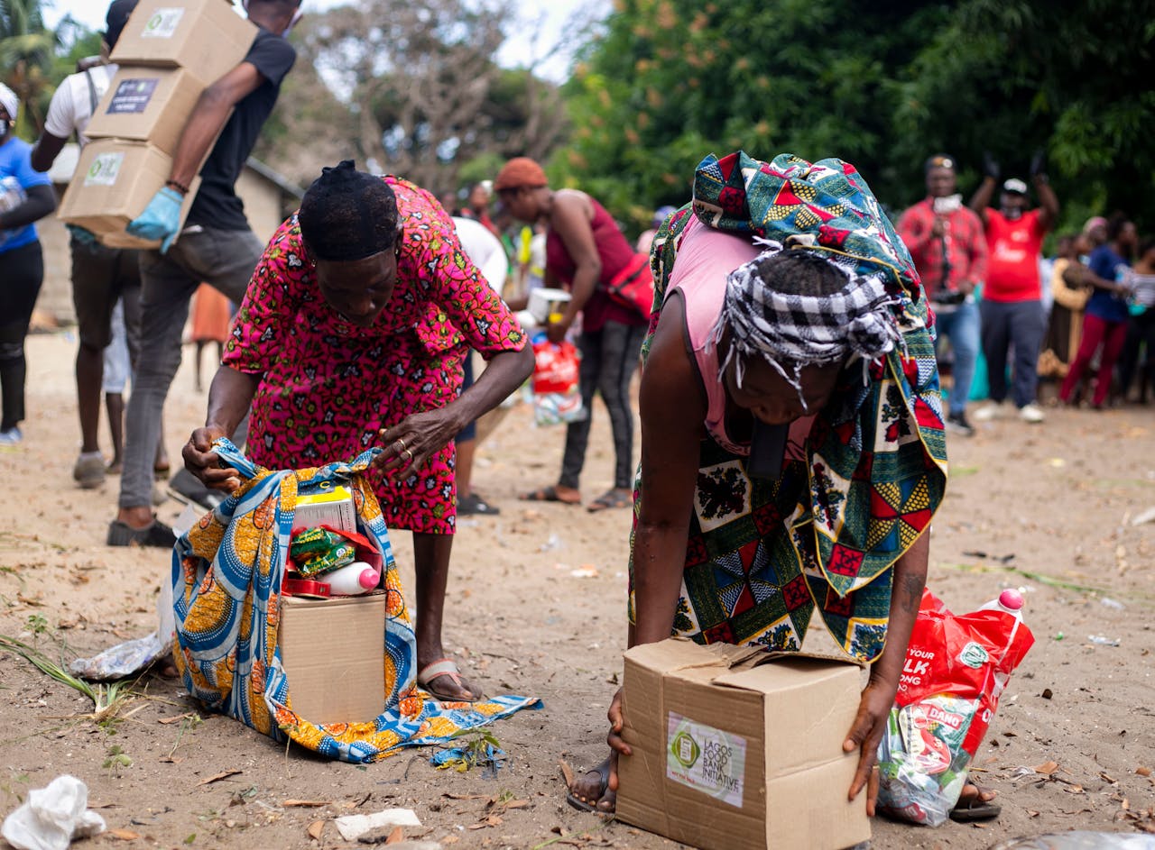 People collecting relief supplies in a community outdoor setting.